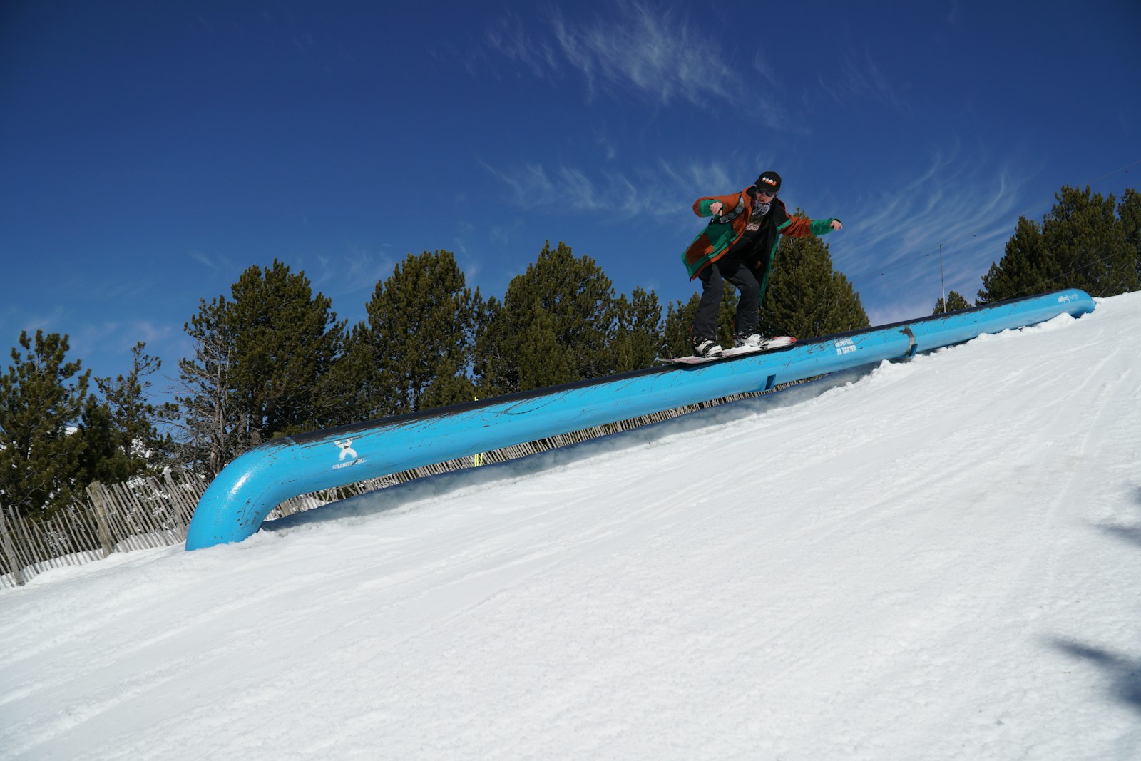 Snowboarder riding a rail in a terrain park